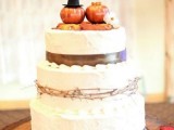 a white buttercream wedding cake with brown ribbons, twigs and pumpkins on top is a very lovely and cool idea