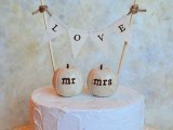 a white buttercream wedding cake with mini sugar pumpkins and a banner is a lovely and cozy idea for a rustic wedding
