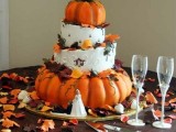 a fall wedding cake with white buttercream and pumpkin tiers, with fall leaves and calligrpahy is a gorgeous rustic wedding idea