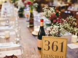 a simple and lovely cluster wedding centerpiece of burgundy blooms and baby’s breath, a camera, a table number is a pretty idea for a vintage wedding