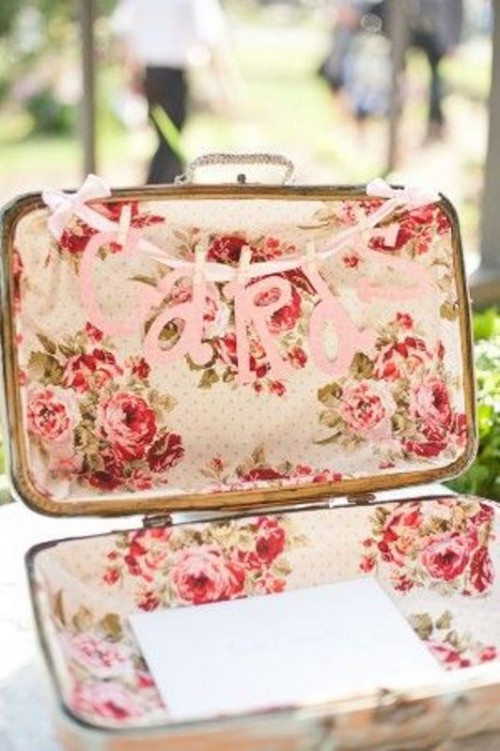 a vintage suitcase with bright floral lining is a cool idea for a vintage wedding and a letter banner explains what to do