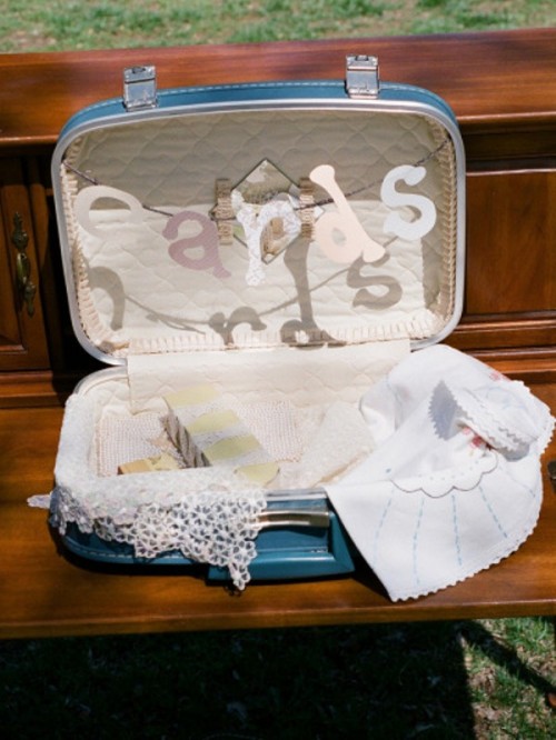 a vintage blue suitcase with a letter banner and some lace is a cool wedding card box idea for a vintage wedding