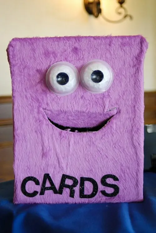 a unique monster-shaped lilac faux fur card box with googly eyes is a fun and cool idea for a Halloween wedding
