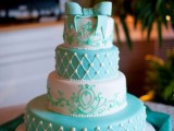 a tiffany blue and white wedding cake decorated with patterns and a large sugar bow on top