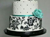 a black and white wedding cake with beads and flroal patterns and tiffany blue sugar blooms will highlight your wedding color scheme
