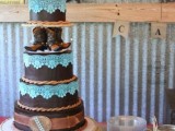 a whimsical chocolate wedding cake decorated with ribbons, tiffany blue lace, cowboy boots and unique toppers