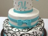 a black and white wedding cake with tiffany blue decor – ribbons, bows and a monogram