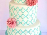 a white wedding cake with tiffany blue patterns and coral blooms is a bright and cheerful option for summer
