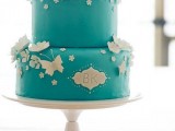 a tiffany blue wedding cake with white sugar butterflies and flowers plus monograms
