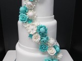 a white wedding cake decorated with neutral and tiffany blue sugar flowers looks elegant and chic