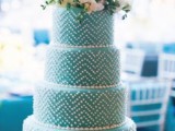 a tiffany blue wedding cake decorated with white sugar beads and fresh neutral blooms on top