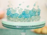 a white wedding cake decorated with aqua and tiffany blue edible sea glass is a great idea for a coastal wedding