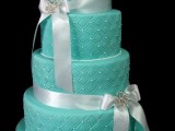 a patterned and textural tiffany blue wedding cake decorated with beads and ribbon bows