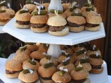 a simple white stand of wood with burgers on mini skewers is a great mini burger stand for any wedding