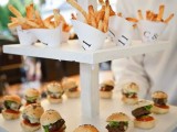 a modern stand with mini burgers and paper cones with French fries is a perfect wedding food station for a modern casual wedding