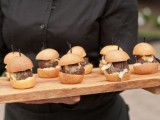 a wooden tray with burgers and skewers is a cool idea for a modern wedding that isn’t too formal
