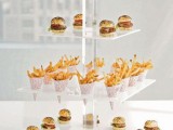 a sheer acrylic stand with mini burgers and paper cones with French fries is a perfect idea for a modern wedding