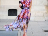 a sleeveless flowy midi watercolor dress in lots of shades, a black clutch and red shoes