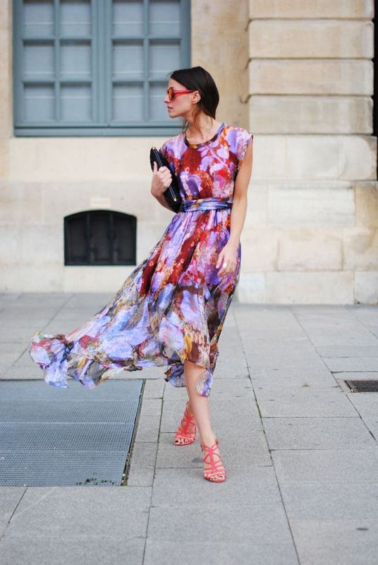 A sleeveless flowy midi watercolor dress in lots of shades, a black clutch and red shoes