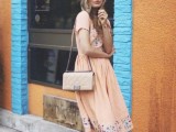a blush midi dress with floral embroidery in blue, nude shoes and a nude bag for a spring wedding
