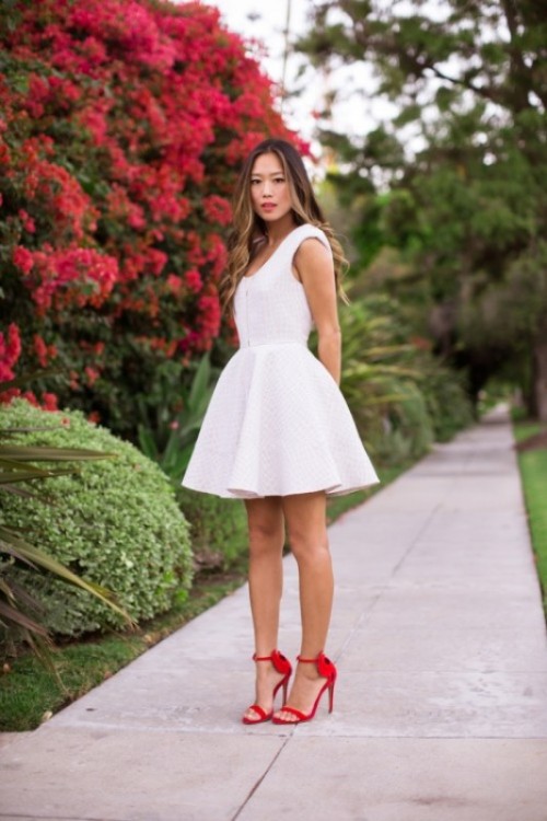 a white A-ine mini dress with no sleeves, a deep cut and red shoes for a bold and cool modern look