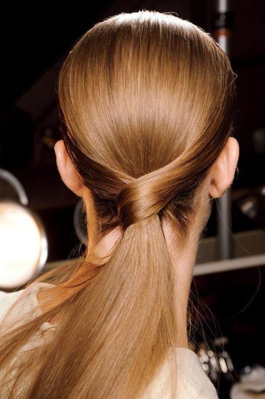 an elegant low twisted ponytail with a sleek top is a chic and cool idea for a modern or minimalist bride