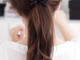 a lovely messy and wavy low ponytail with a black ribbon bow is a playful and girlish wedding hairstyle idea to try