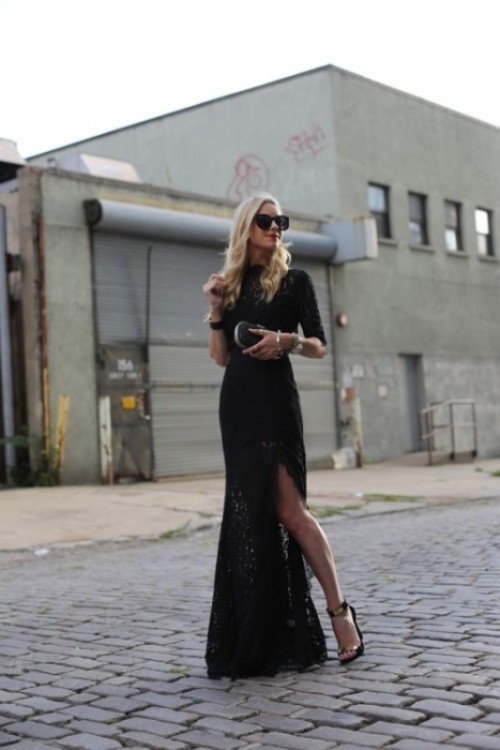 a black lace maxi sheath dress with a turtleneck, short sleeves, a front slit and black heels and a clutch