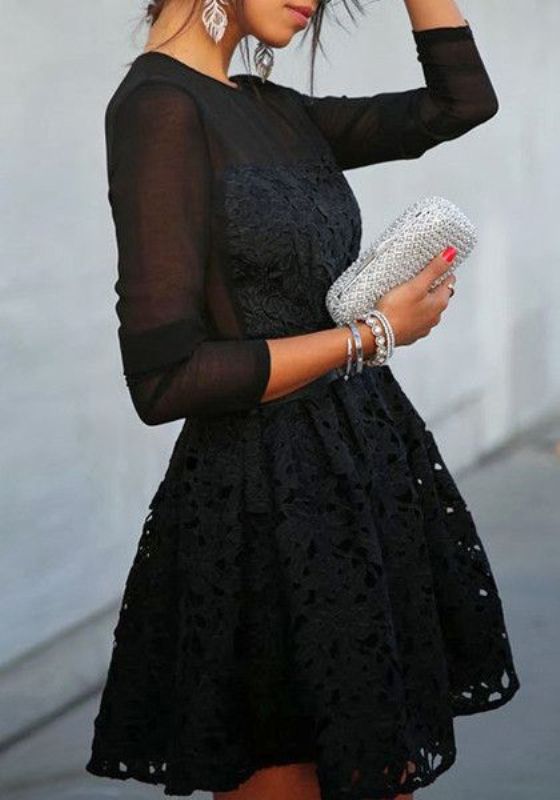 A black A line mini dress with lace detailing, long sleeves and a high neckline, stacked bracelets and a shiny silver clutch