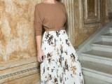 a tan long sleeve top, a floral white a-line midi skirt, white heels and statement earrings for a bold look