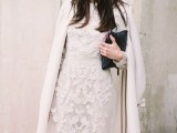 a white lace sheath knee dress, a white coat, a black leather clutch for a refined winter wedding guest look