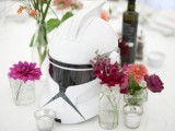 a Stromtrooper mask and bold blooms and candles compose a bold and very cool Star Wars themed wedding centerpiece