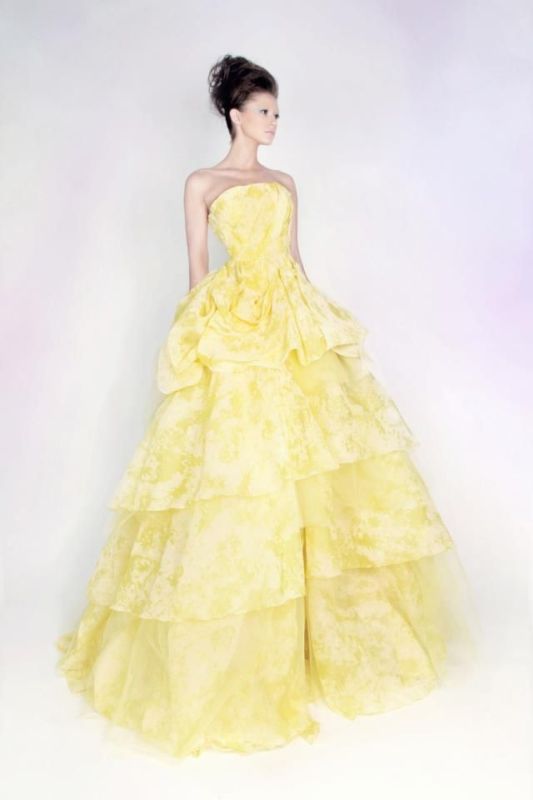 A yellow and white strapless wedding ballgown with a ruffled skirt is a bold statement you may make with both color and design