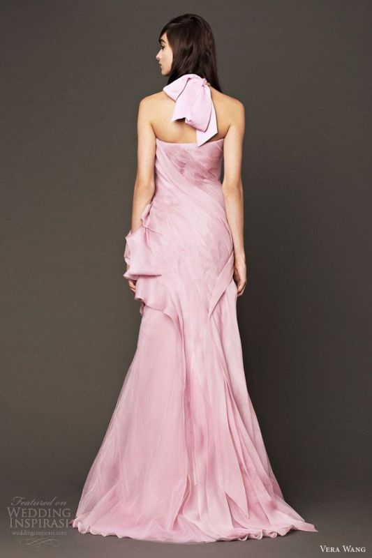 A pink wedding dress with a draped bodice and skirt, a large bow on the neck for a soft touch of color