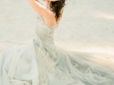 a sea foam colored A-line wedding dress with a lace bodice and a layered skirt with a train for a coastal wedding