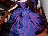 a statement purple iridescent wedding ballgown with an off the shoulder neckline and a super long train plus a hat is wow