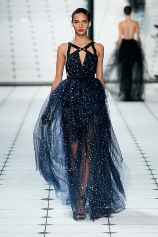 A midnight blue a line wedding dress with thick black straps and a layered skirt is fully embellished and very bold, great for a celestial bride