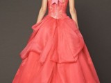 a red strapless wedding ballgown with a lace bodice and a layered skirt, a pink ribbon bow on the neck is a statement
