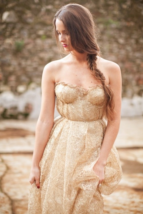 a delicate strapless gold wedding dress with a bustrier bodice and a pleated neckline plus a full pleated skirt for a romantic bride