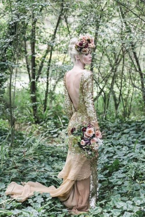 a gold sequin mermaid wedding dress with long sleeves, an open back and a tan sheer tail and train