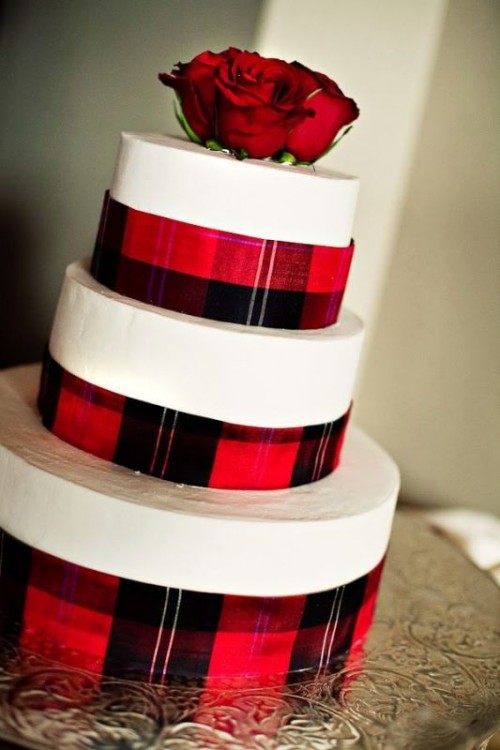 a white wedding cake with plaid ribbons and red roses is a stylish winter wedding dessert