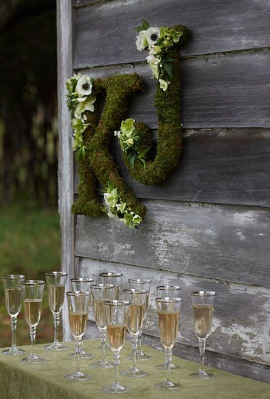 Moss letters decorated with white ranunculus are a cool rustic decoration for any wedding