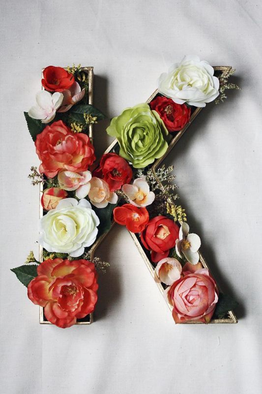a large monogram done with red and white blooms and some greenery is a simple and stylish idea