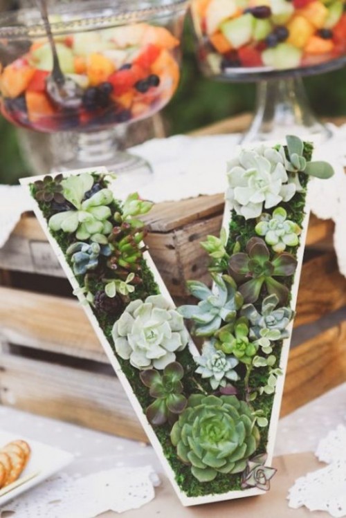 a large monogram done with moss and succulents is a very trendy idea for a wedding centerpiece