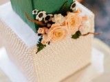 a beautiful green and white square wedding cake with a sleek and textural tier, with sugar and usual blooms and leaves is refined
