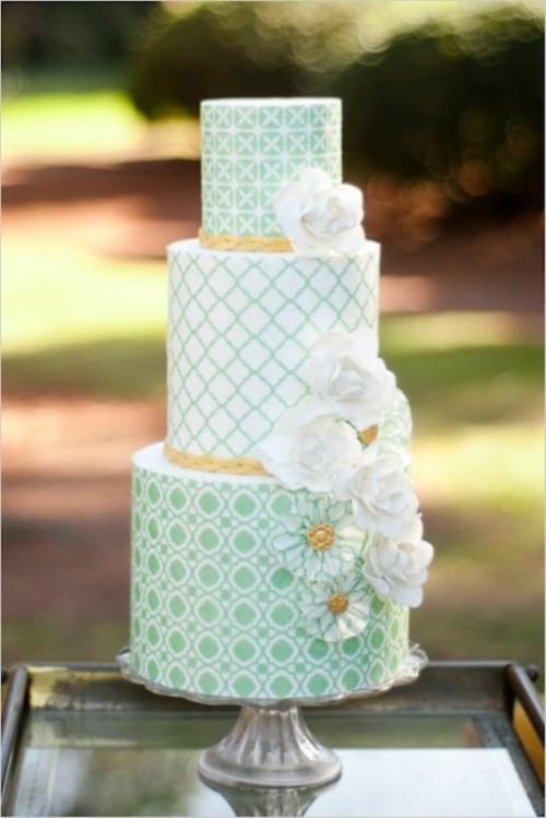 a light green and white patterned wedding cake with white and green sugar blooms for a vintage spring or summer wedding