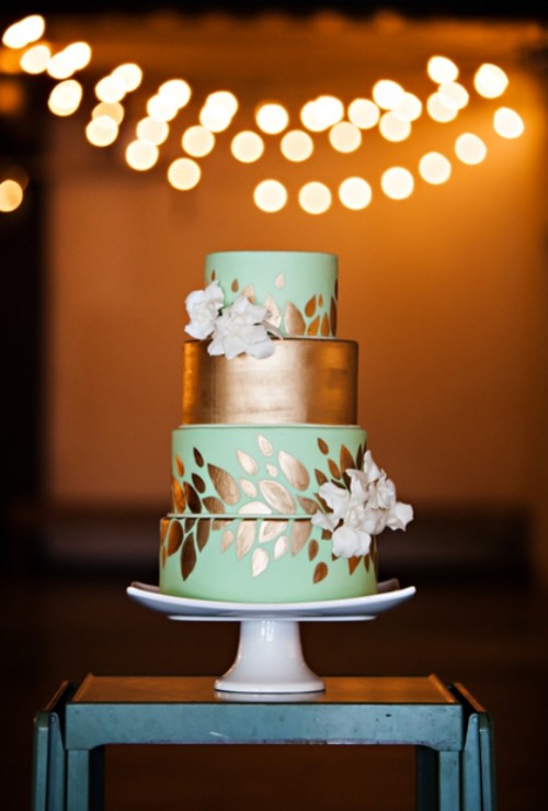 an exquisite light green and copper wedding cake with botanical patterns, a copper tier and white blooms is fantastic