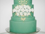 a pretty green wedding cake with white blooms, gold detailing is a very elegant and chic idea for a spring wedding