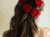 a messy half updo accented with red roses is a beautiful and very chic idea for a modern and romantic Valentine’s Day bride