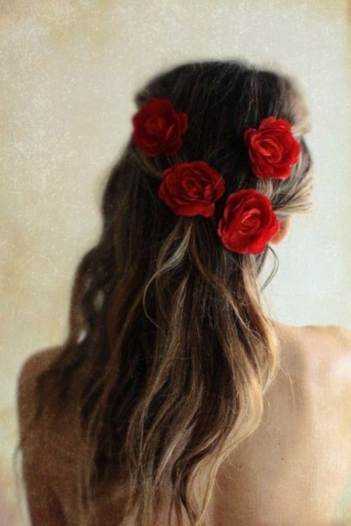 a messy half updo accented with red roses is a beautiful and very chic idea for a modern and romantic Valentine's Day bride